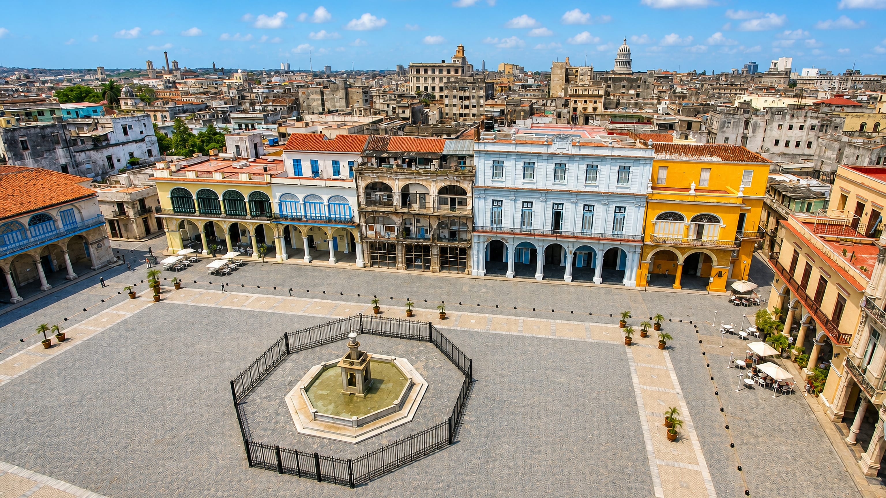 Plaza Vieja in La Habana Vieja, Cuba, with arcaded colonial facades, fountain and Capitolio dome.