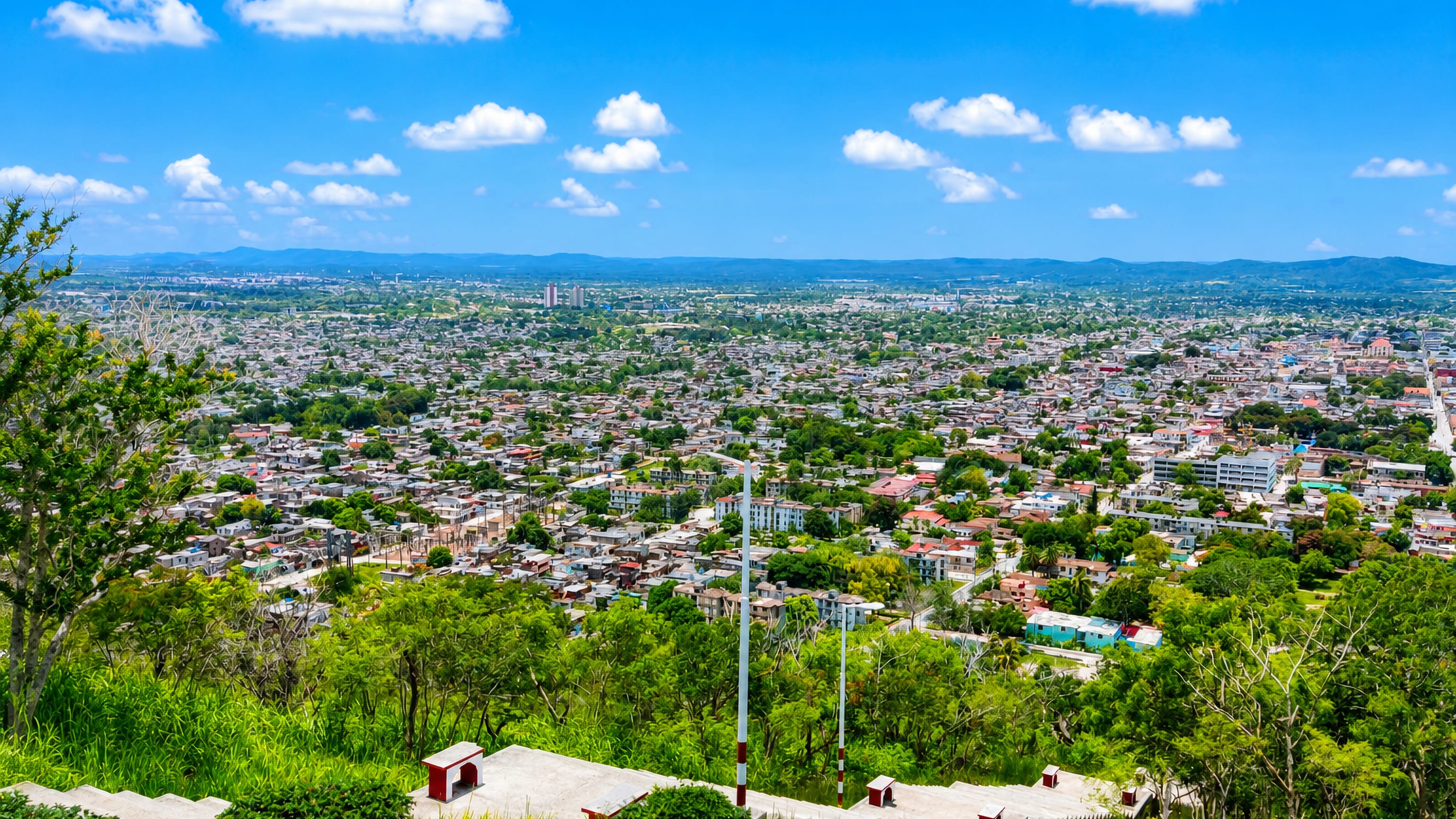 Holguín, Cuba, spread across the plain below the Loma de la Cruz hilltop stairway, with hills on the horizon.