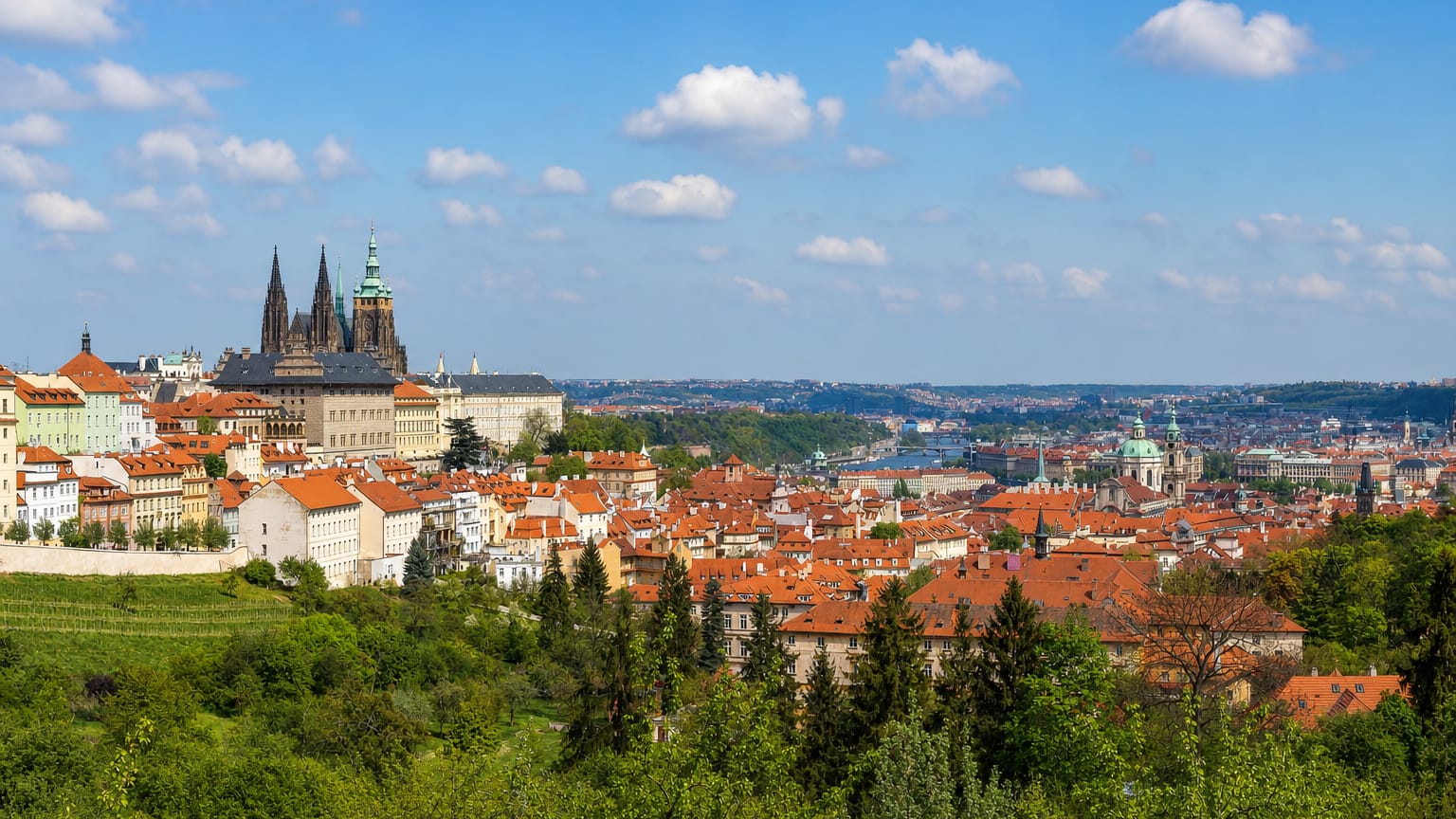 Prague Castle and St. Vitus Cathedral rising above the red rooftops of Mala Strana