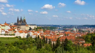 Prague Castle and St. Vitus Cathedral rising above the red rooftops of Mala Strana