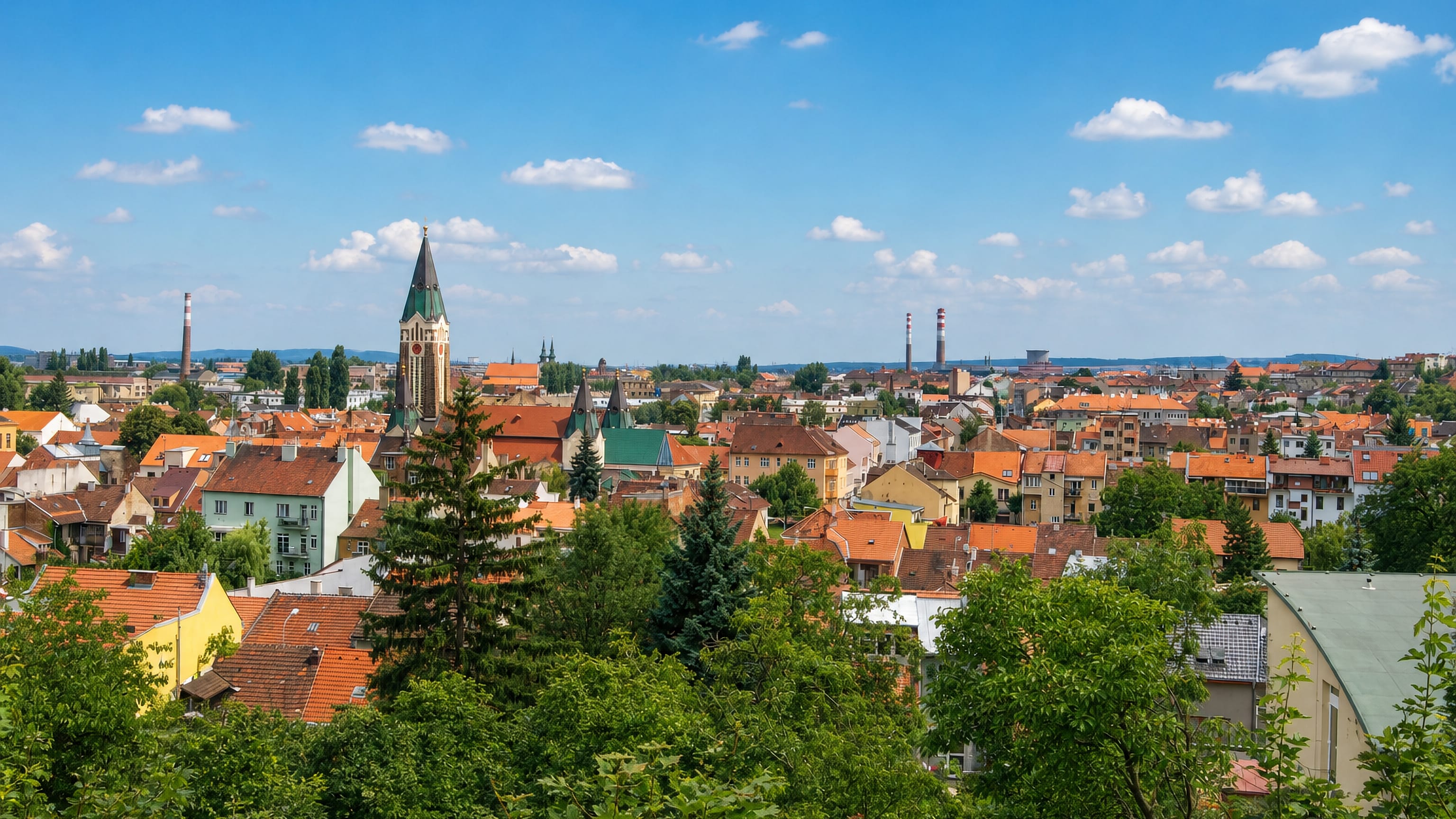Red-tiled rooftops, a green church spire and industrial chimneys across Husovice in northern Brno.