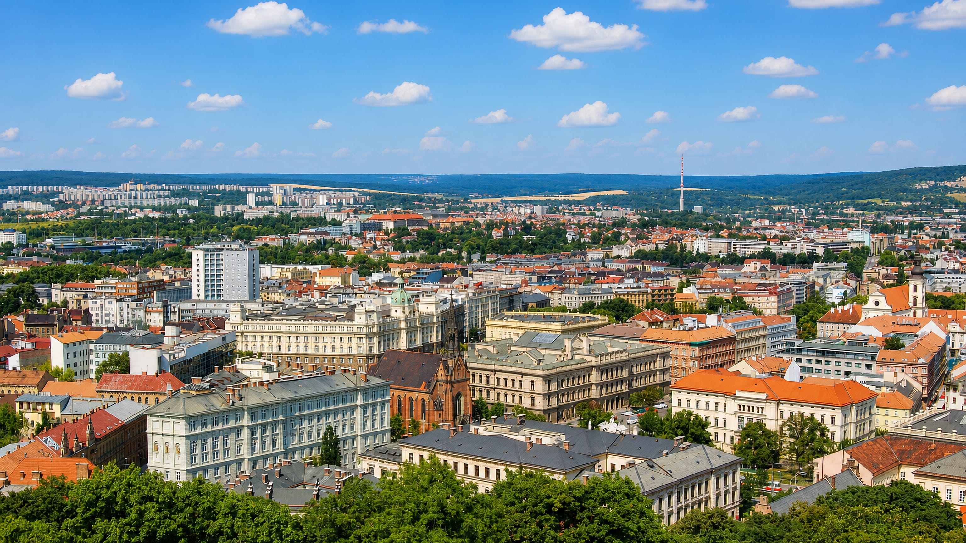 Panorama over Veveří, Brno, with the red-brick Red Church, grand 19th-century blocks and the TV tower beyond.