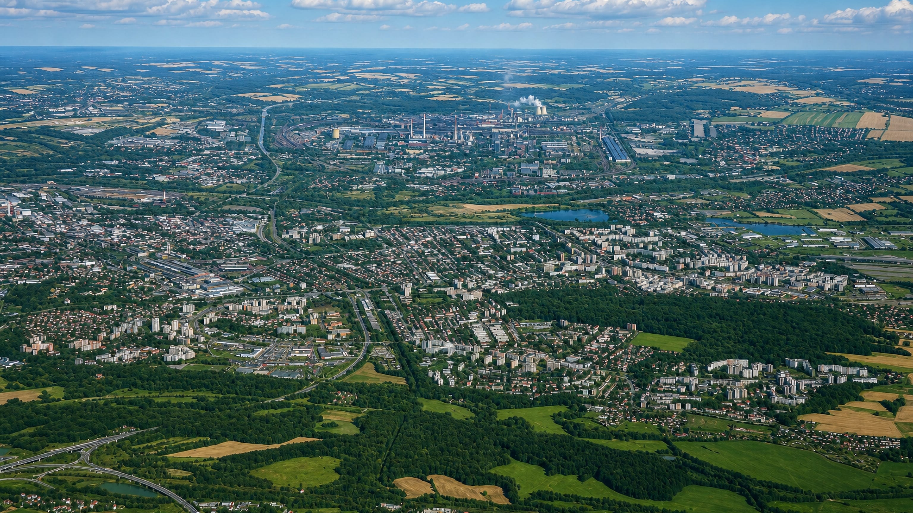 High aerial over Ostrava-Jih, its housing estates and green belts with the city's steelworks on the horizon.