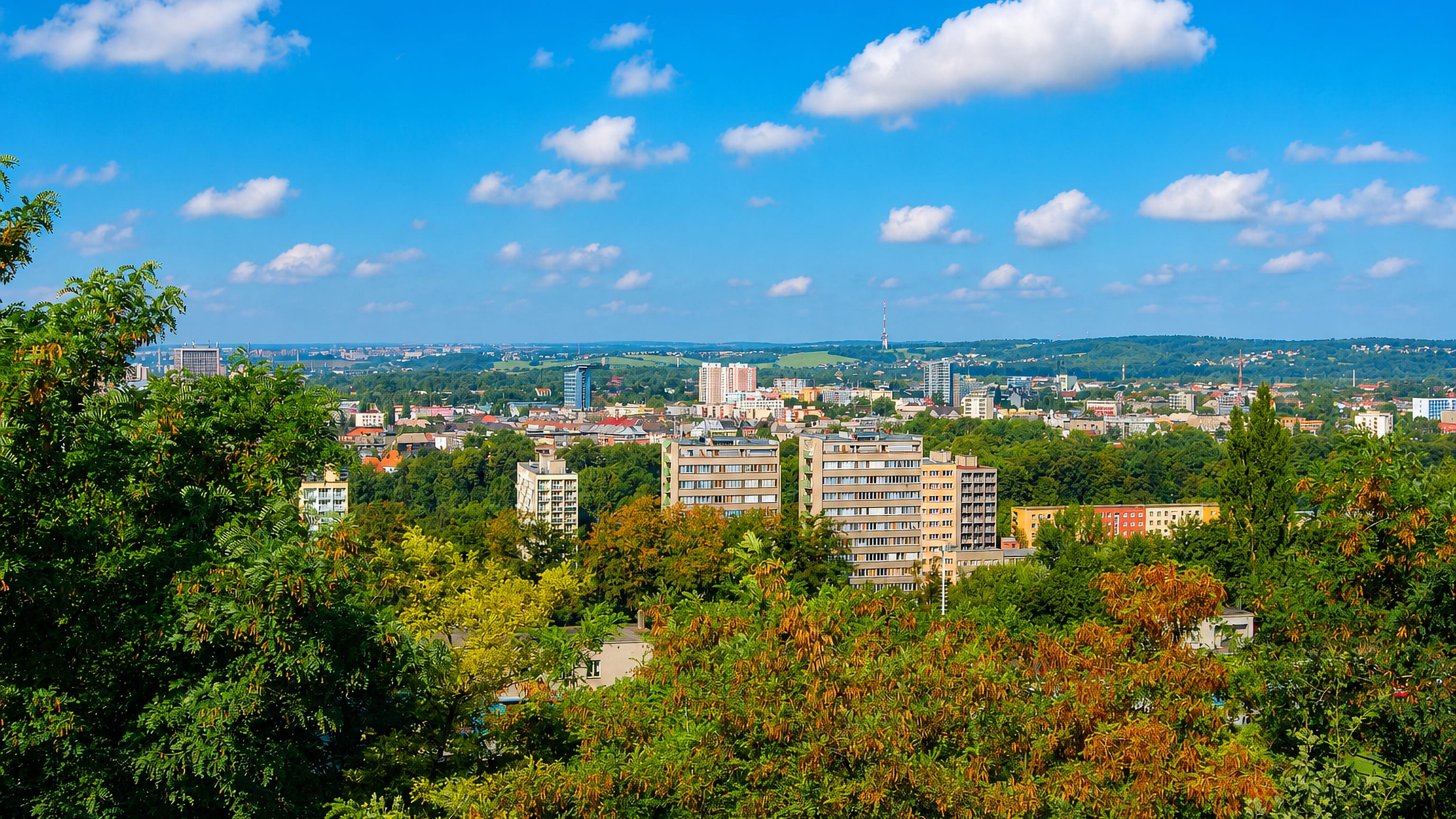 Ostrava's apartment blocks and transmitter tower seen across wooded slopes from Slezská Ostrava.