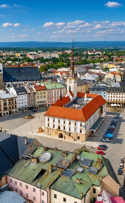 Aerial view of Olomouc's Upper Square with the town hall, Holy Trinity Column and red-tiled old town.