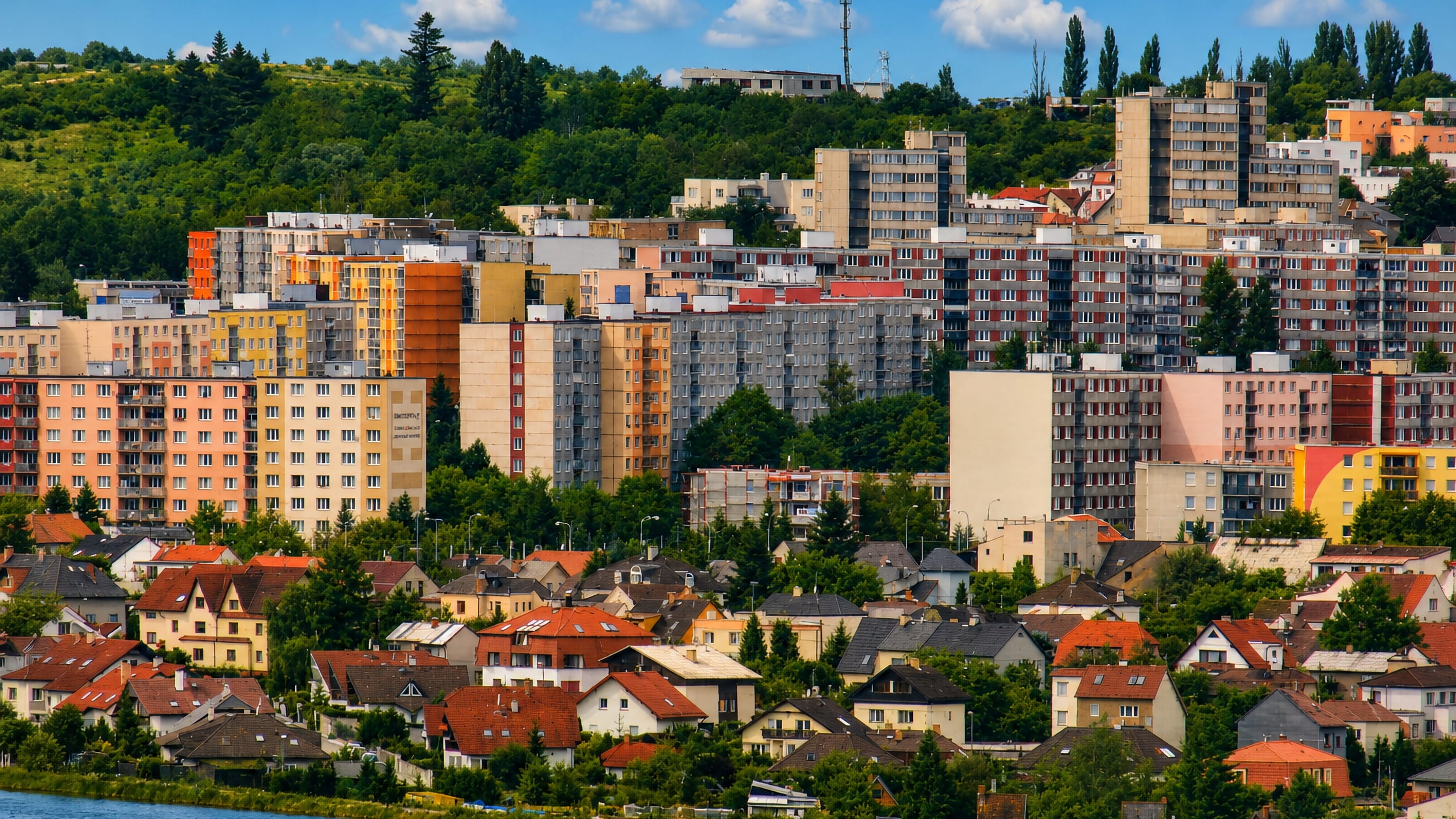 Panel-block housing estate of Lochotin rising above family houses and the river in Plzen.