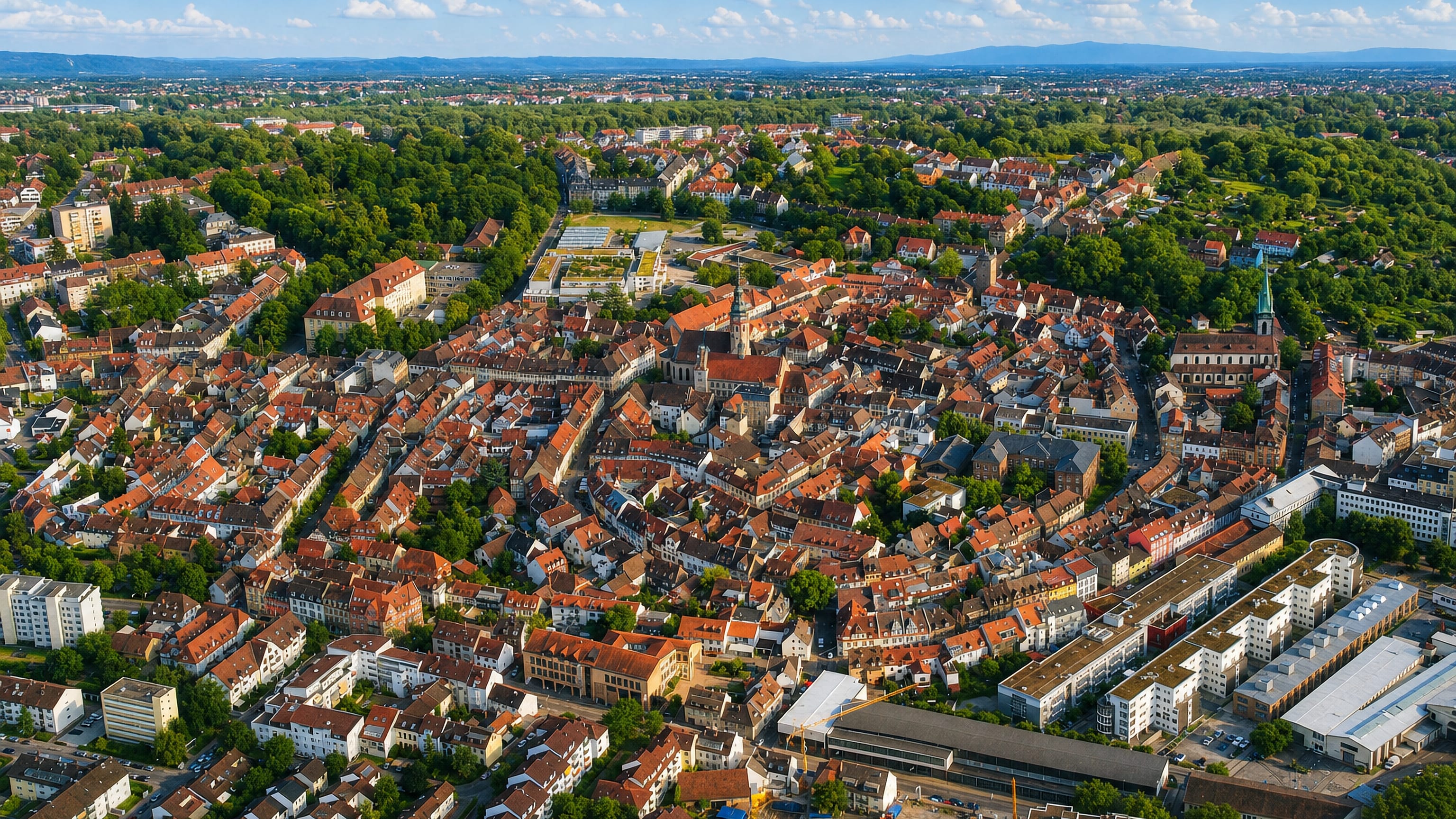 Aerial over Durlach's old town in Karlsruhe, red roofs and parks ringing the church tower.