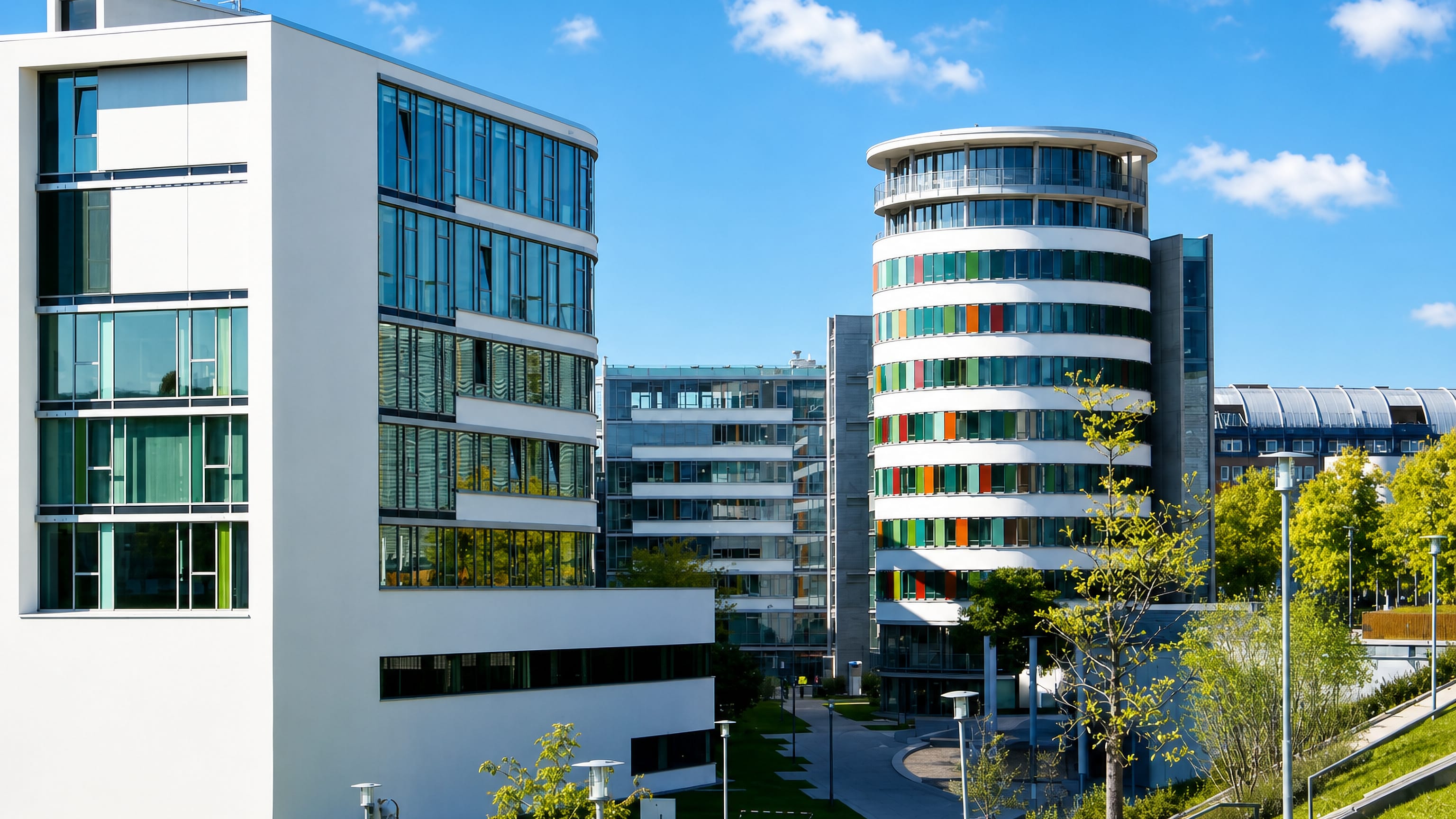 Modern white offices and a colourful round tower beside landscaped lawns in Karlsruhe's Südstadt