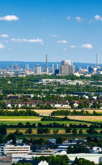 Mannheim skyline with its telecommunications tower rising beyond farmland and suburban rooftops.