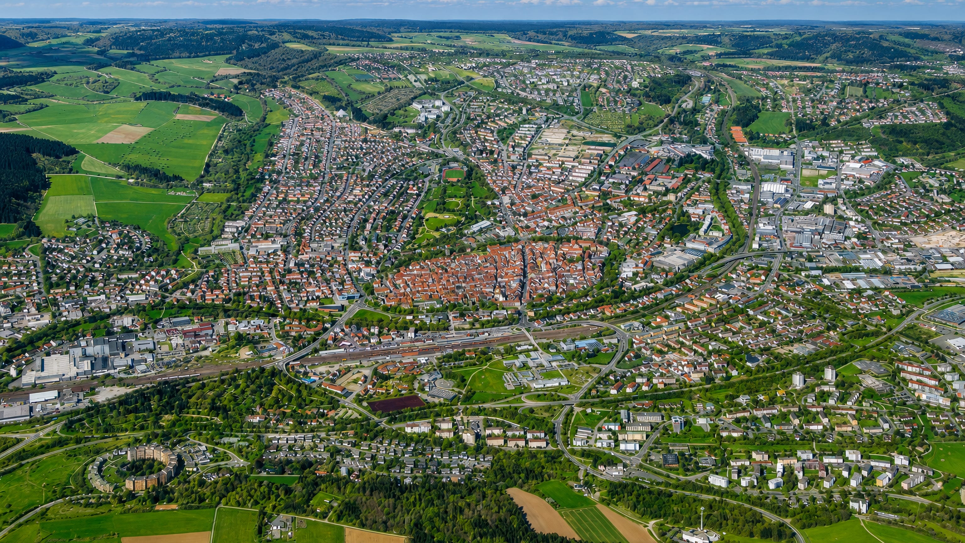 Aerial view of Villingen-Schwenningen, Germany, with its red-roofed old town, rail lines and Black Forest farmland