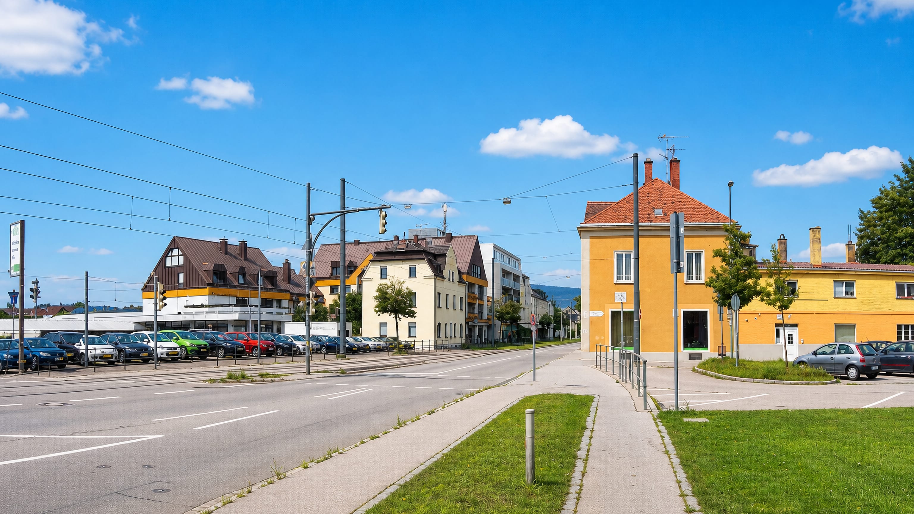 Wide tram-lined avenue past yellow apartment houses and a park-and-ride lot in Kriegshaber, Augsburg.