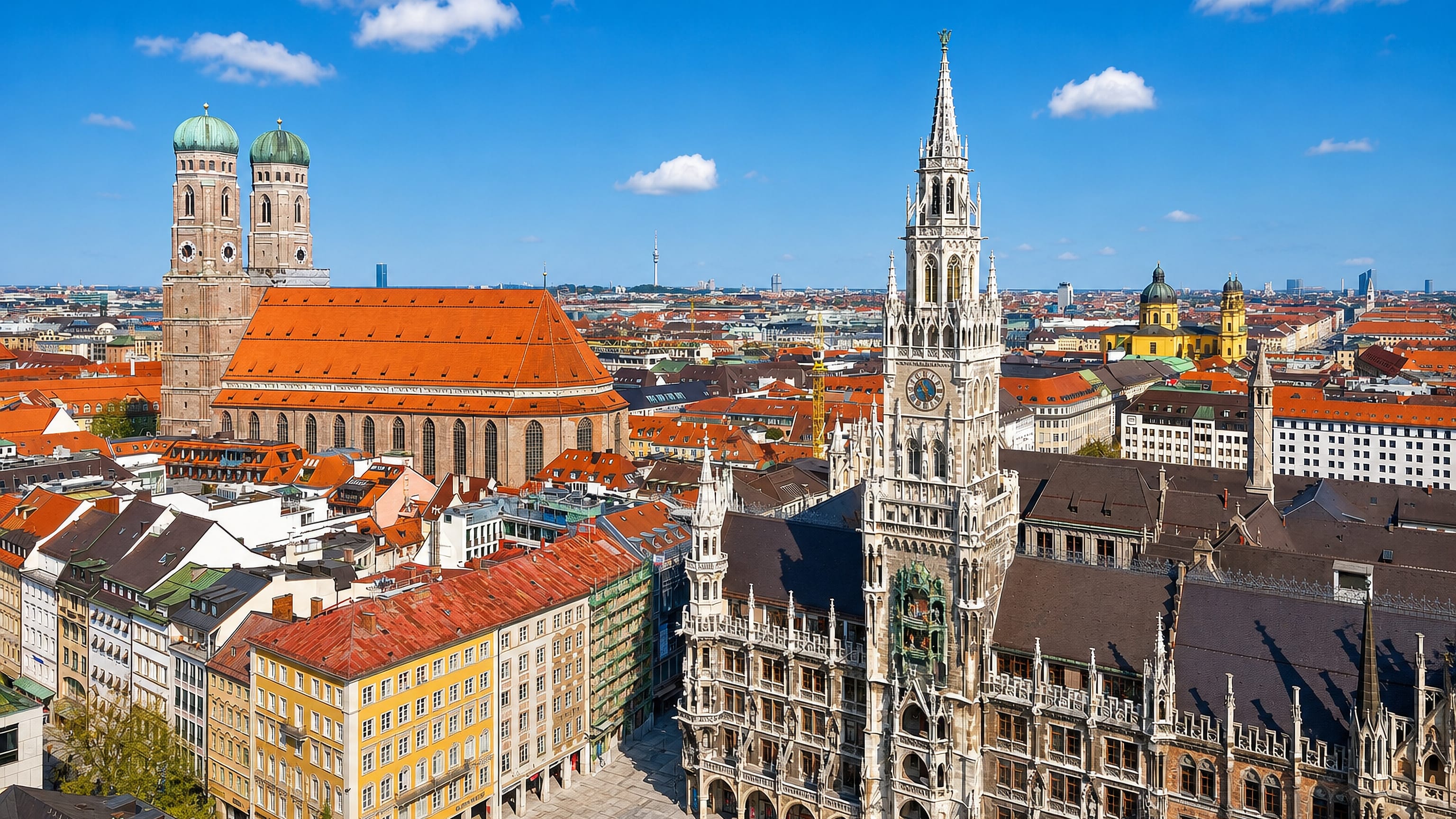 Munich's Marienplatz with the New Town Hall clock tower, Frauenkirche domes and old town rooftops.