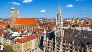 Munich's Marienplatz with the New Town Hall clock tower, Frauenkirche domes and old town rooftops.