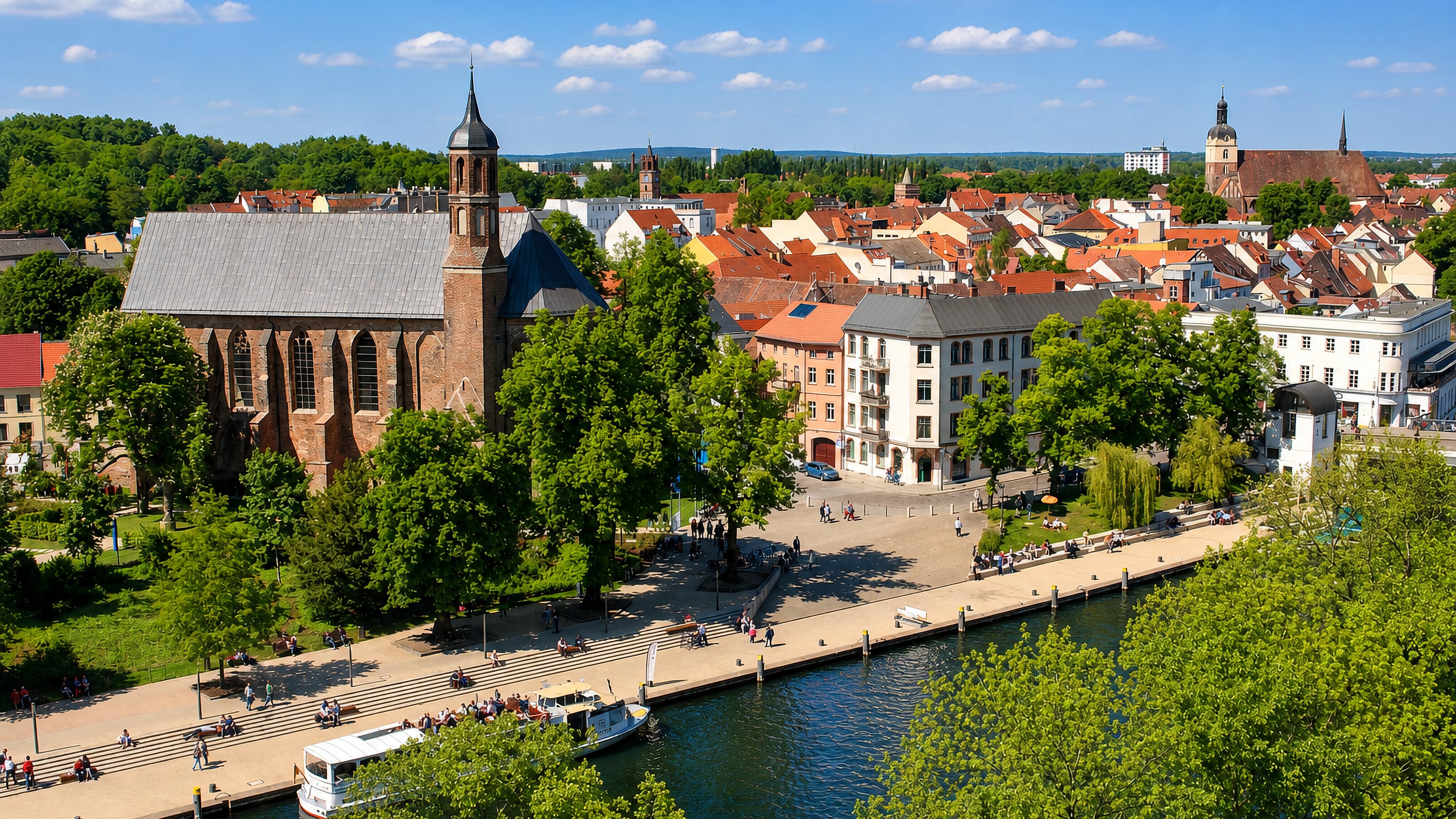 Brick Gothic St John's Church and the Havel riverside promenade with tour boats in Brandenburg an der Havel