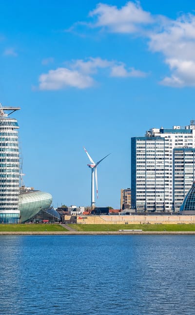 Bremerhaven's Havenwelten waterfront with the Sail City tower, Klimahaus pod and harbour high-rises under blue sky