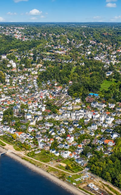 Aerial of hillside villas descending to the Elbe riverside beach and lighthouse in Blankenese, Hamburg