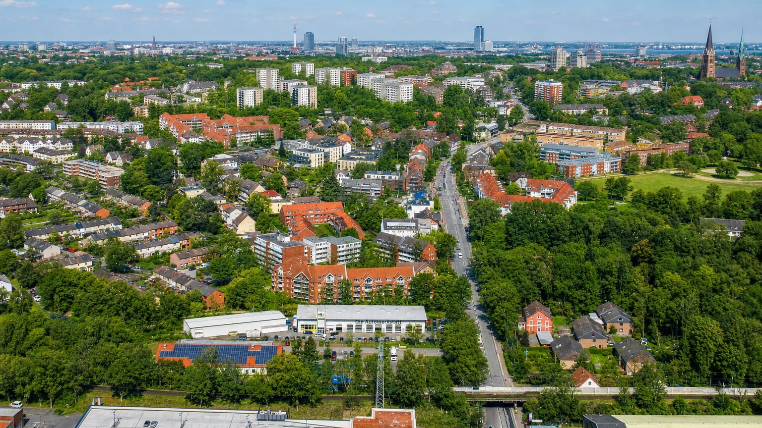 Aerial over the dense Eimsbüttel district of Hamburg with the Heinrich-Hertz TV tower and city skyline on the horizon