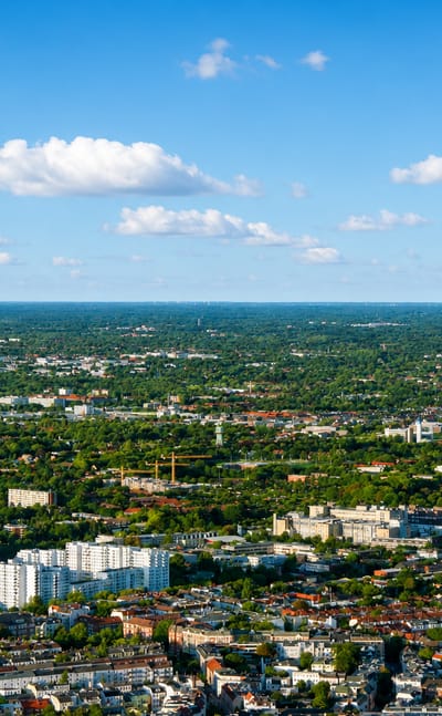 Aerial cityscape of white apartment blocks and low red-roofed housing amid greenery in Eppendorf, Hamburg.