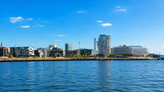 Hamburg's HafenCity waterfront on the Elbe, with the wave-topped Marco Polo Tower and modern quayside buildings.