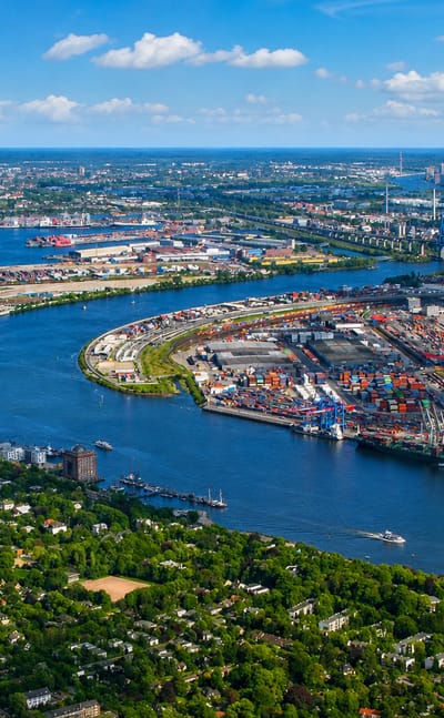 Aerial view over the Elbe from Othmarschen, leafy Hamburg riverside suburb facing the container port and harbour cranes