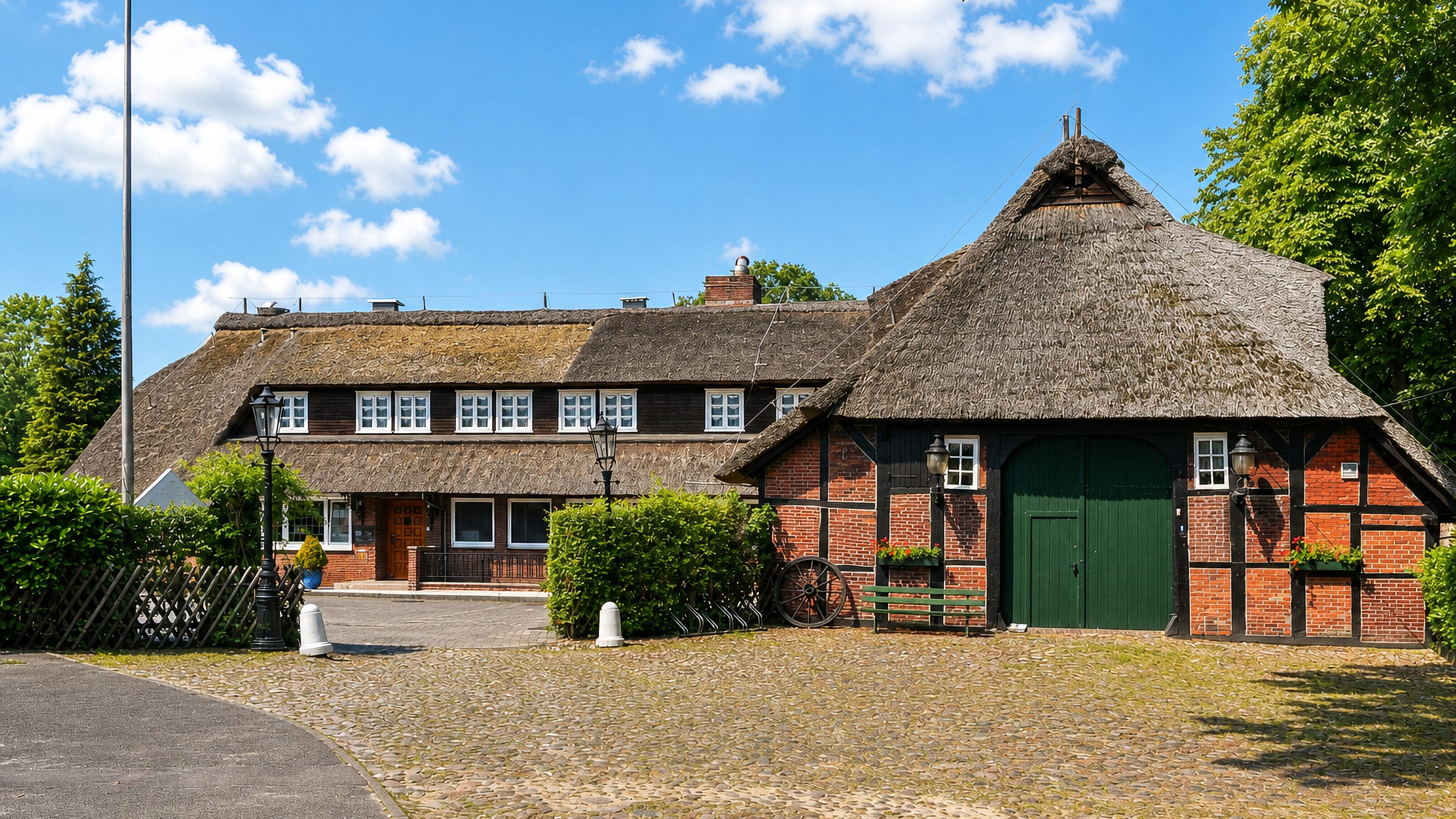 Thatched half-timbered farmhouse on a cobbled forecourt in the Hamburg district of Sasel.