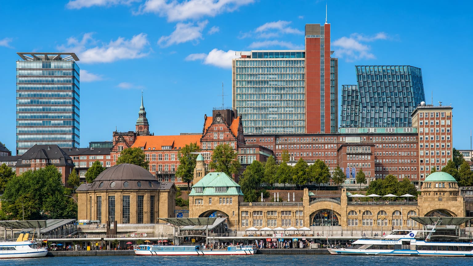 The arcaded copper-domed St. Pauli Landungsbrücken piers on the Elbe waterfront with modern towers behind in Hamburg.