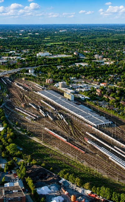 Aerial view of the railway yards and green suburban surroundings of Stellingen in Hamburg on a sunny day.