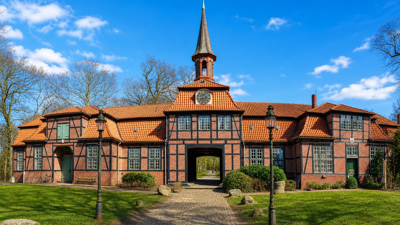 The half-timbered Wellingsbuttel Torhaus manor gatehouse with clock tower and cobbled path in Hamburg's Wellingsbuttel