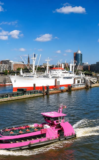 Hamburg harbour with the Elbphilharmonie, the Cap San Diego museum ship and a pink harbour ferry under blue sky, near Wilhelmsburg