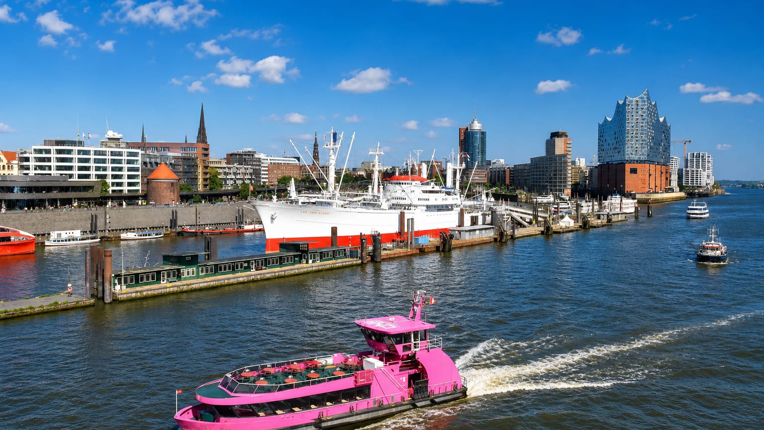 Hamburg harbour with the Elbphilharmonie, the Cap San Diego museum ship and a pink harbour ferry under blue sky, near Wilhelmsburg