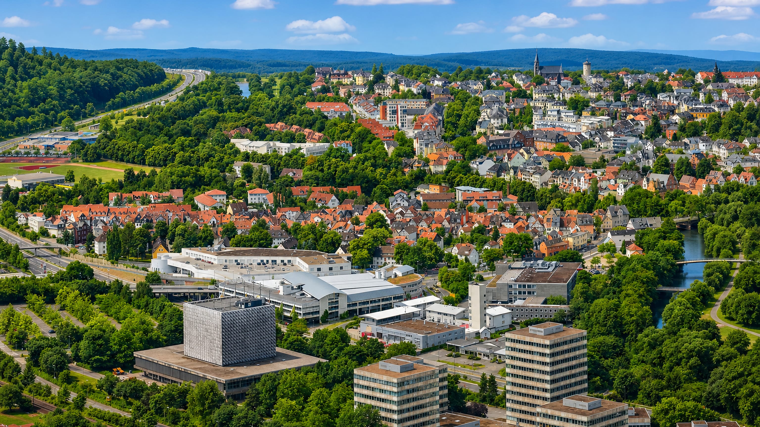 Aerial view of Weidenhausen with the Lahn river, old-town rooftops and university buildings in Marburg.