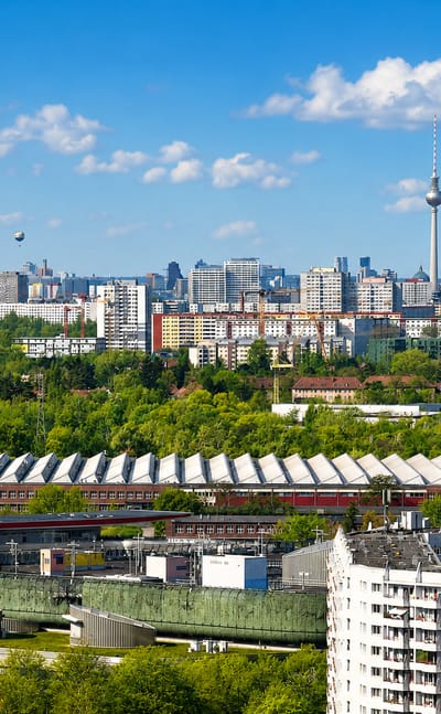 Townscape of Alt-Hohenschonhausen in Berlin with residential and industrial buildings and the Fernsehturm on the horizon
