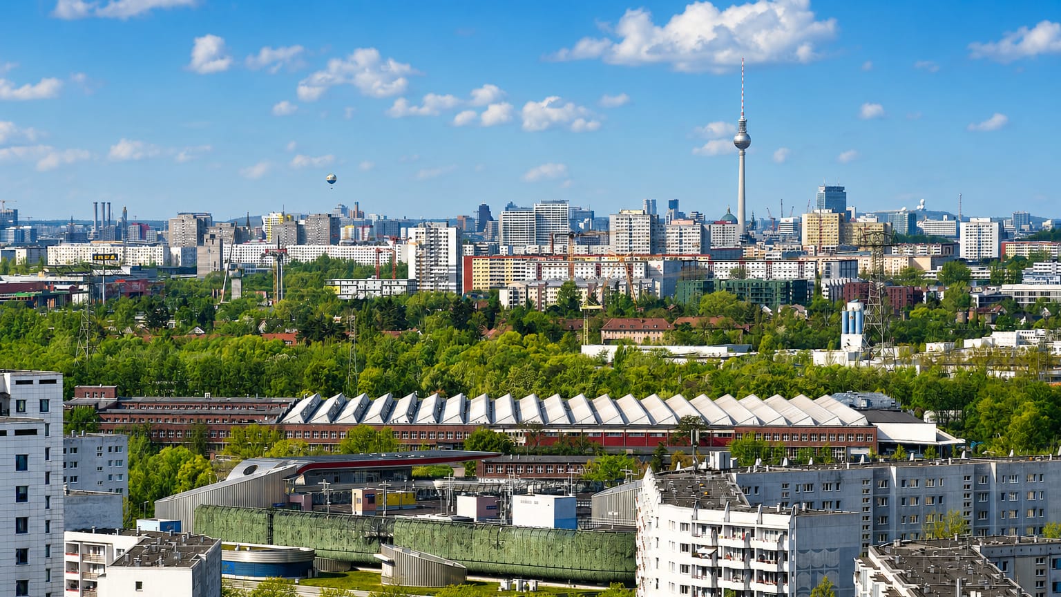 Townscape of Alt-Hohenschonhausen in Berlin with residential and industrial buildings and the Fernsehturm on the horizon