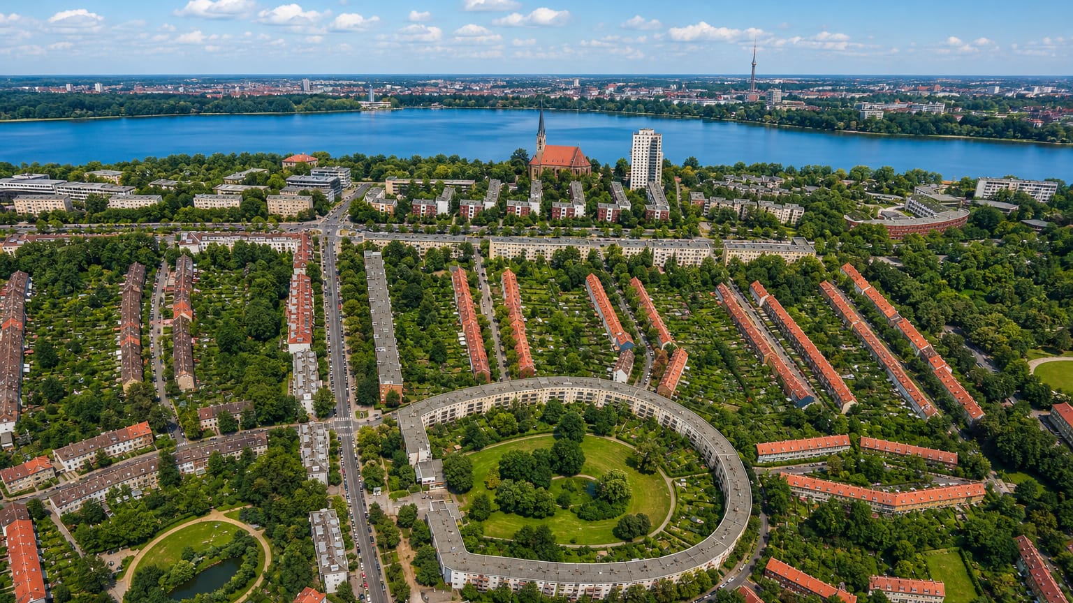 Aerial of Britz in Berlin showing Bruno Taut's horseshoe-shaped Hufeisensiedlung estate with the TV tower on the horizon