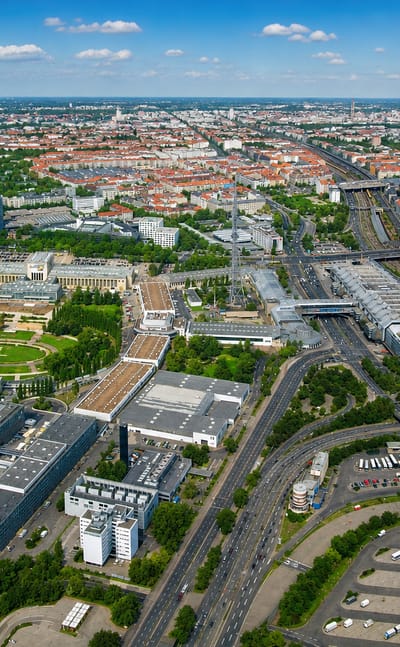 Aerial daytime view over Charlottenburg-Nord in Berlin, with industrial halls, a motorway interchange, rail lines and the Spree beyond.