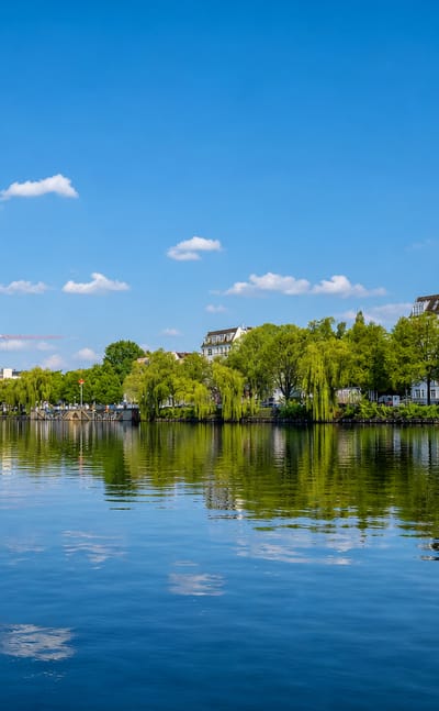 The Spree in Berlin's Friedrichshain with the twin-towered Oberbaumbrücke and riverside brick loft buildings.