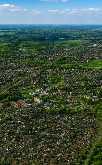 Aerial view over the low-rise suburban streets, allotments and green fields of Karow, Berlin