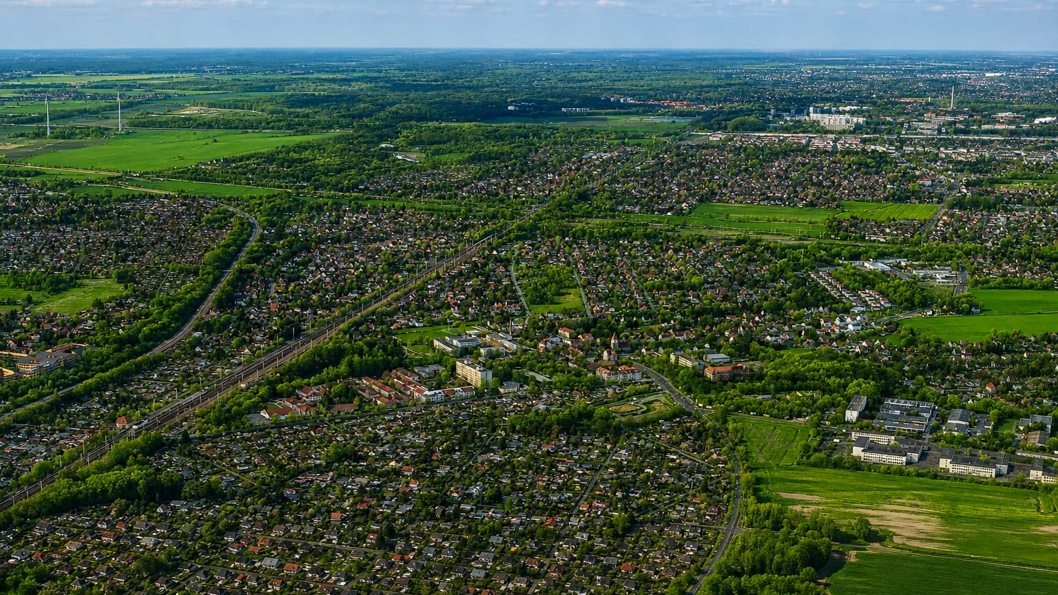 Aerial view over the low-rise suburban streets, allotments and green fields of Karow, Berlin