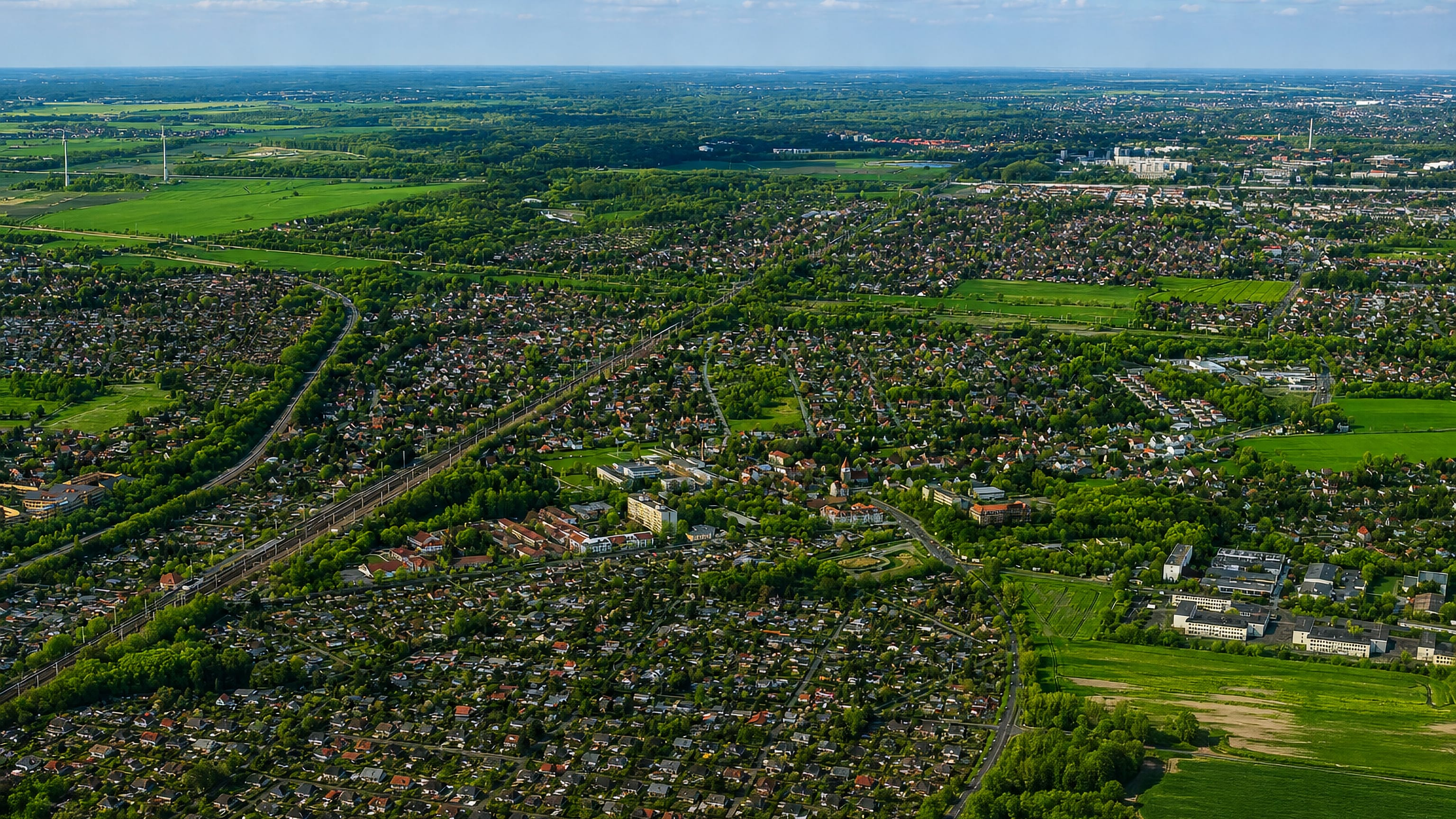 Aerial view over the low-rise suburban streets, allotments and green fields of Karow, Berlin