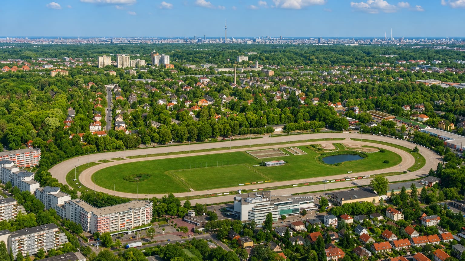 Aerial view of Berlin's Mariendorf harness-racing track with the district's housing and the distant city skyline