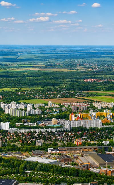 High-altitude aerial of Berlin's Maerkisches Viertel showing its colourful high-rise housing estate amid surrounding greenery