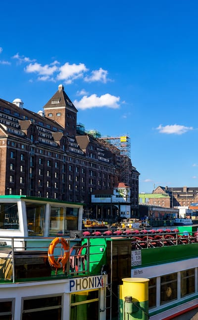 Historic brick harbour warehouse, dockside cranes and an excursion boat at the Westhafen quay in Moabit, Berlin.