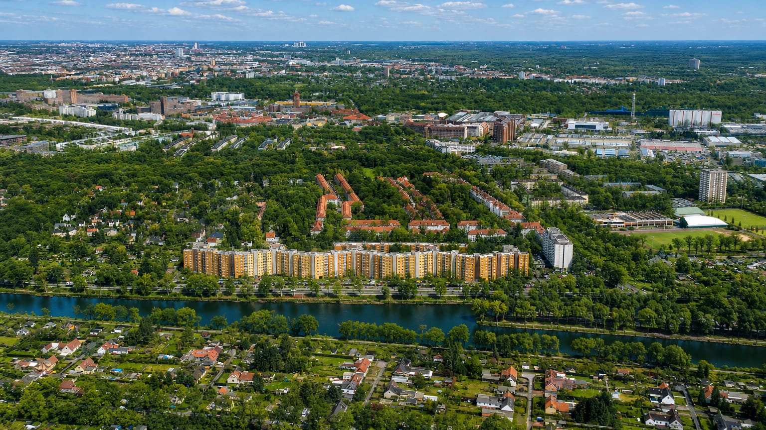 Aerial view of residential apartment blocks and allotment gardens along a canal in Siemensstadt, outer Berlin.
