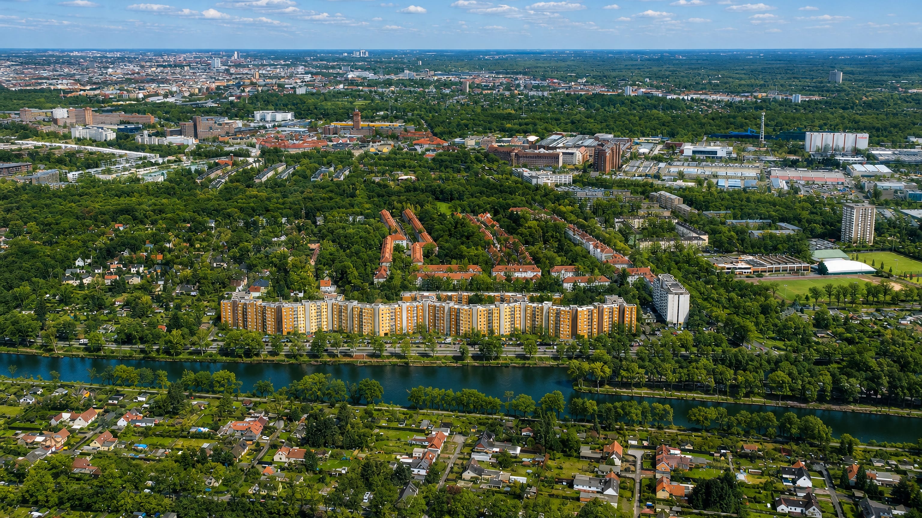 Aerial view of residential apartment blocks and allotment gardens along a canal in Siemensstadt, outer Berlin.