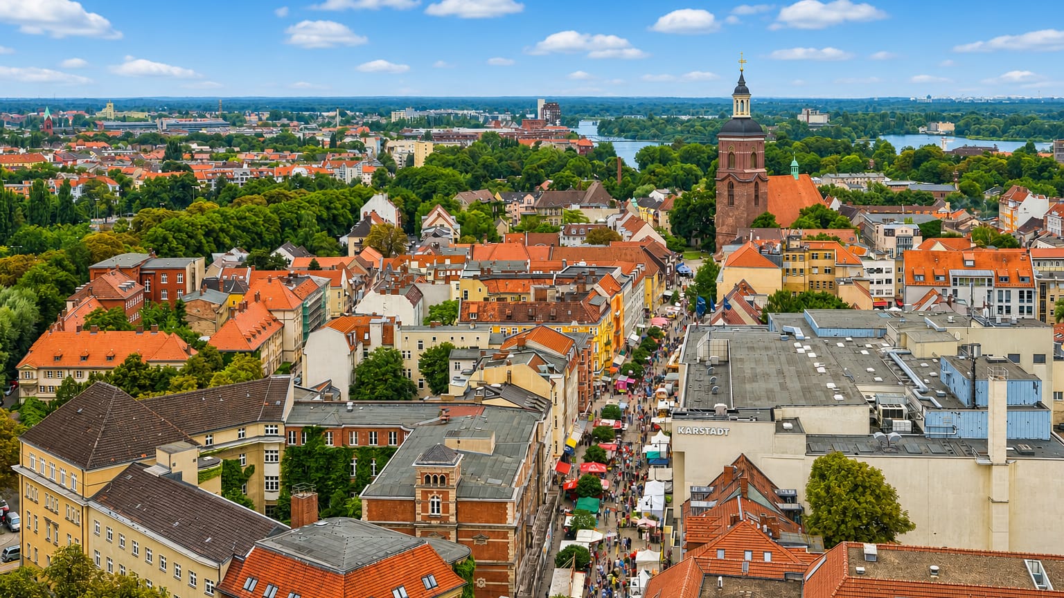 Aerial view of Spandau old town in Berlin with St. Nikolai church tower, red-roofed houses and the Havel river beyond.