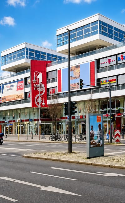 Street view of the Forum Steglitz shopping centre with its red signage and Cineplex in the Steglitz district of Berlin.