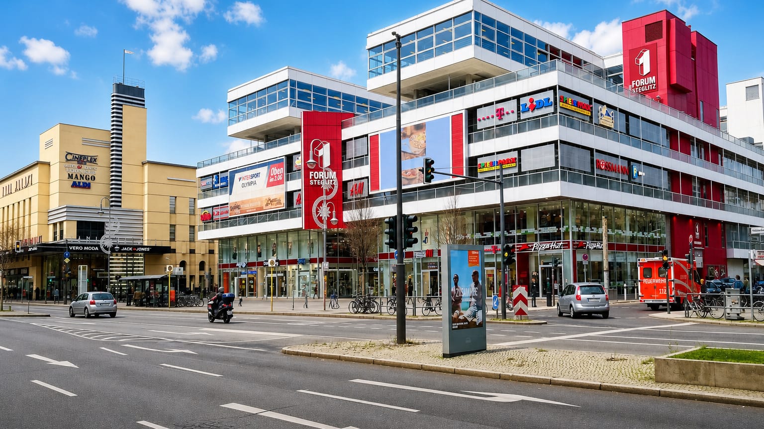 Street view of the Forum Steglitz shopping centre with its red signage and Cineplex in the Steglitz district of Berlin.