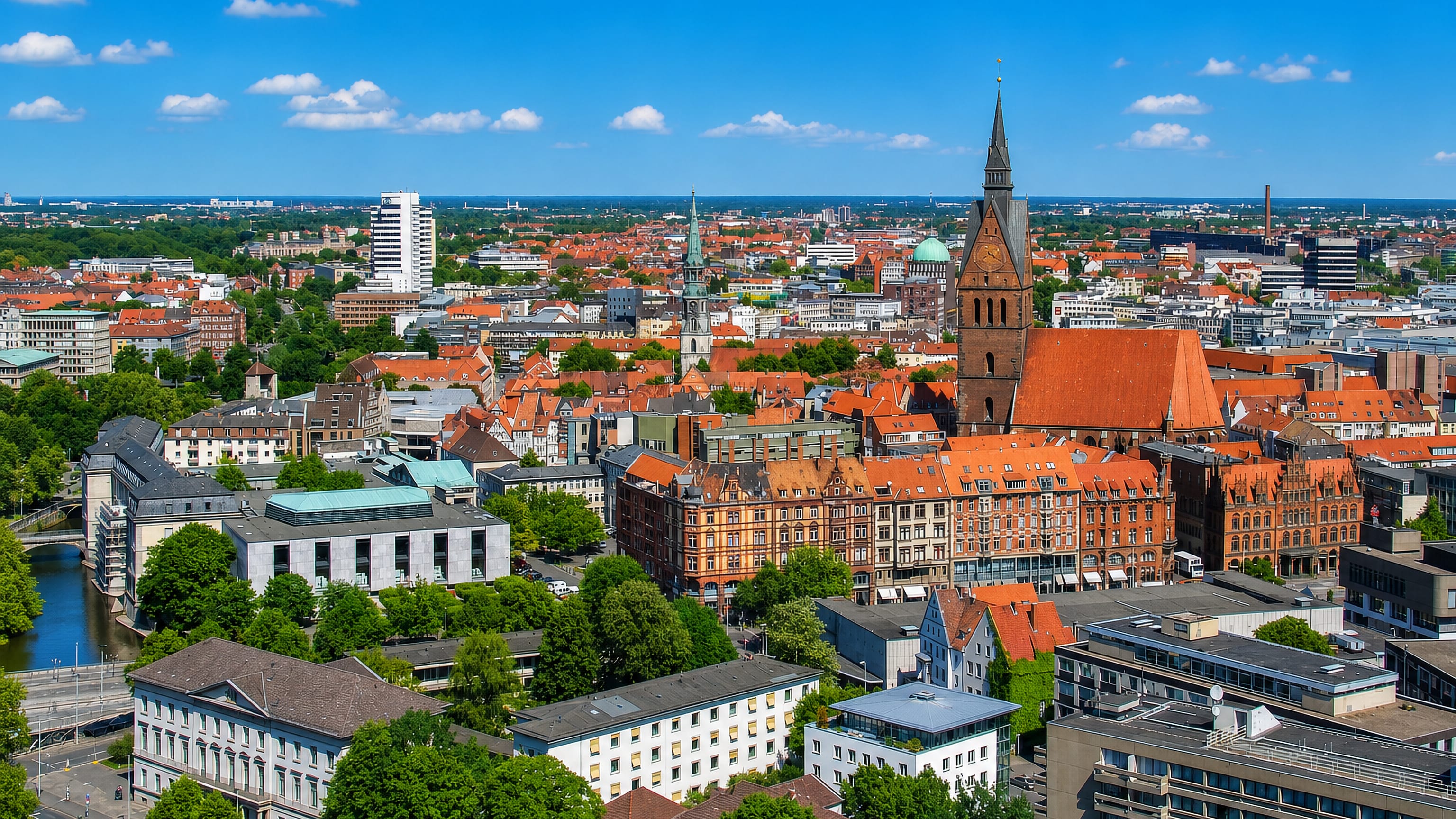 Hannover's old town from above, the brick Marktkirche tower rising over red-tiled roofs and the Leine river