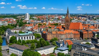 Hannover's old town from above, the brick Marktkirche tower rising over red-tiled roofs and the Leine river