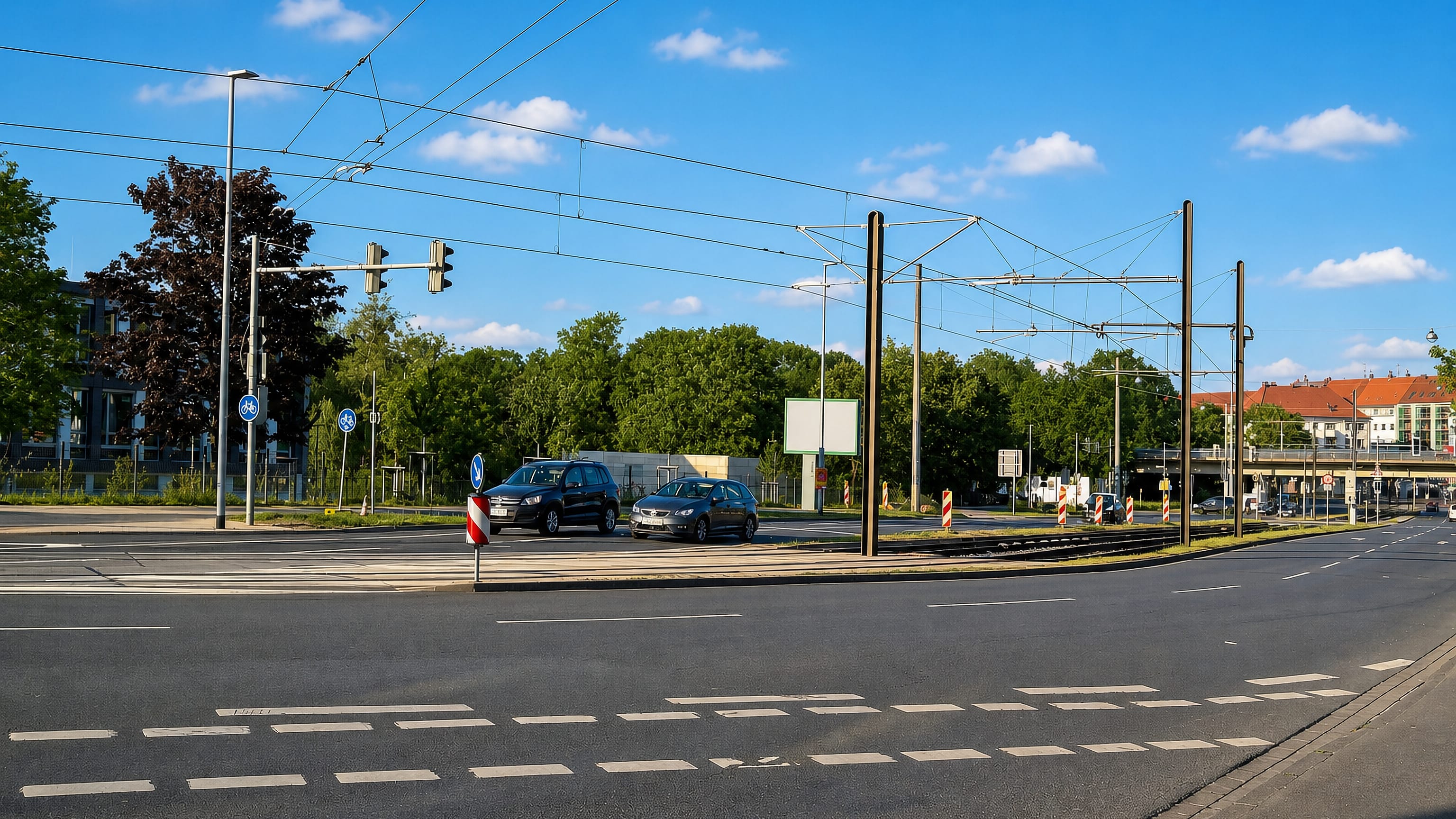 Wide road junction in Limmer, Hannover, with tram overhead lines, apartment blocks and roadside trees.